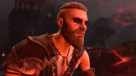 La migliore build Barbarian Baldur's Gate 3: un barb si trova con gli occhi scuri, la barba e bagnati in una luce rossa