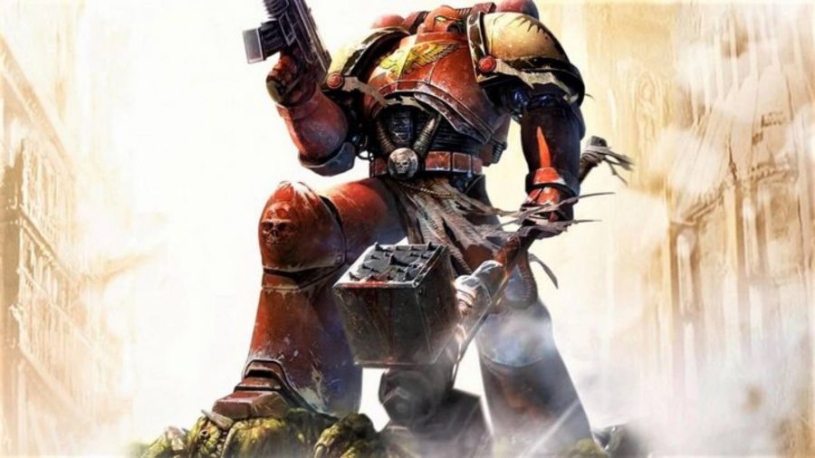 Warhammer 40k Dawn of War 2 - A Warhammer Space Marine in red and gold armor stands with a huge hammer on a rock raising his gun in his left hand
