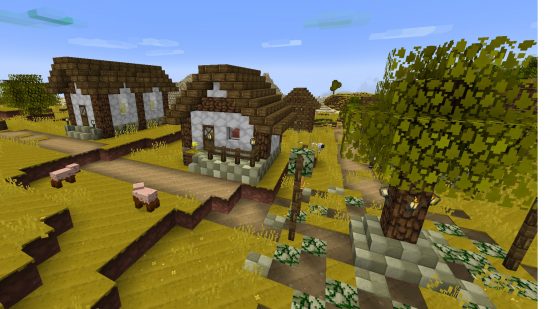 A rustic looking village, each block a different shade to vanilla Minecraft, in the Jolicraft Minecraft texture pack.