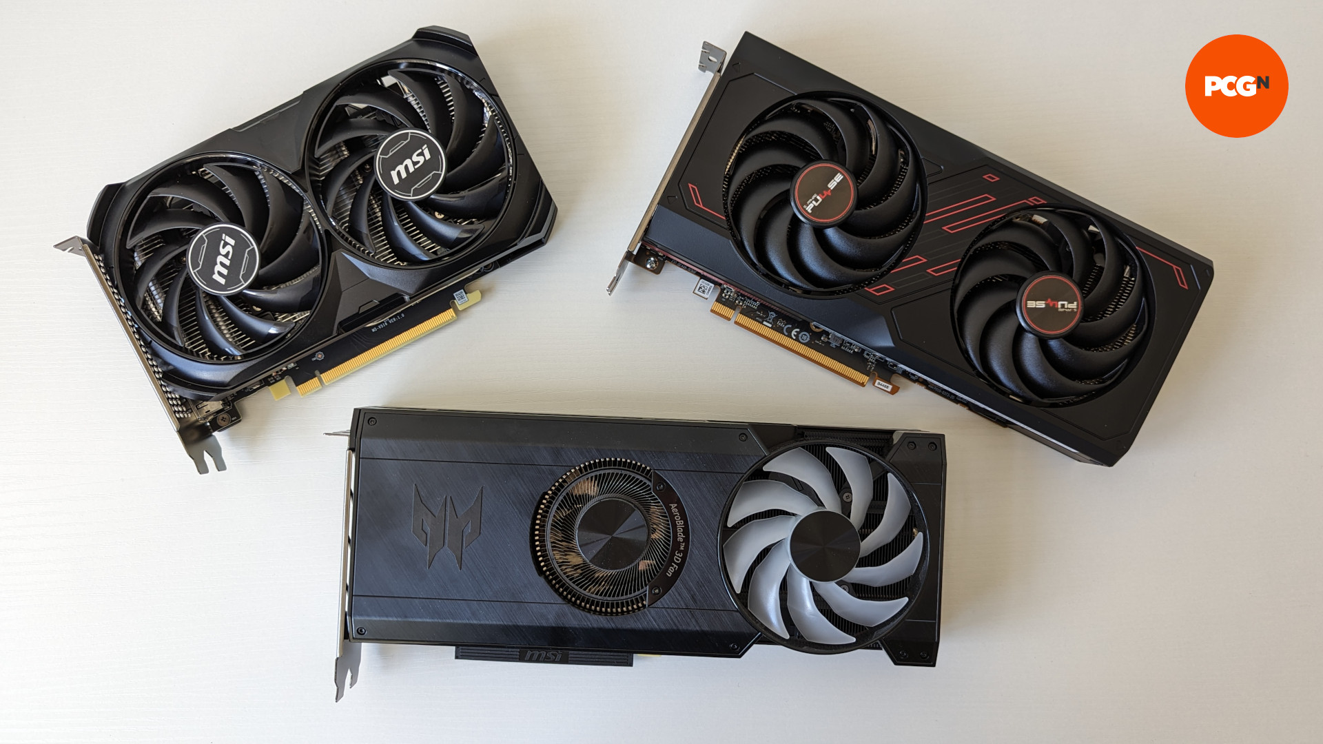 Nvidia Geforce RTX 4060 جائزہ: GPU (اوپر بائیں) RX 7600 (اوپر دائیں) اور انٹیل آرک A770 (نیچے) کے ساتھ ساتھ ایک سفید سطح پر بیٹھا ہے۔