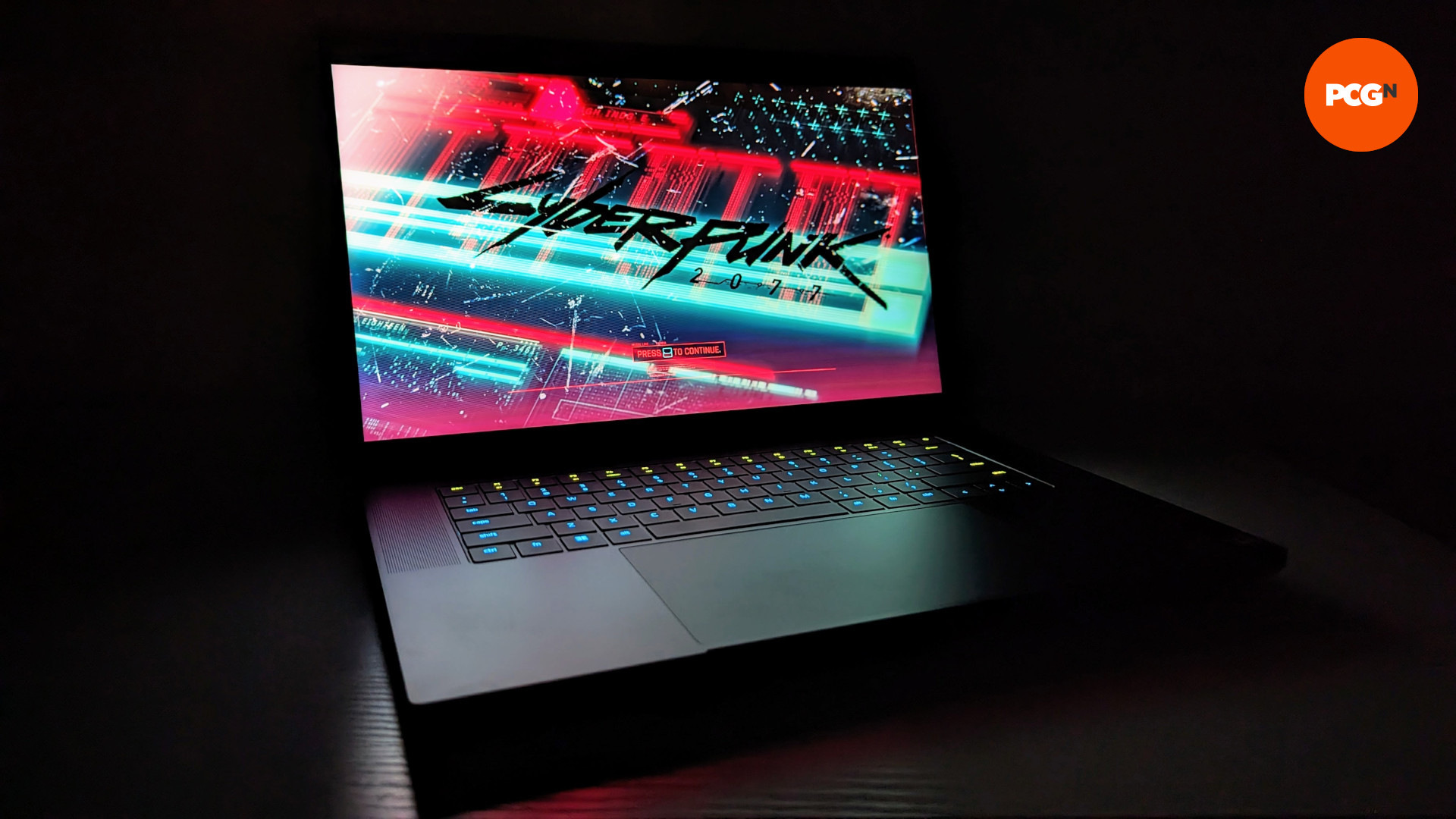 Revisión de Razer Blade 16 (2023): una vista frontal de la computadora portátil, en la oscuridad, con la pantalla de título Cyberpunk 2077 iluminando la escena