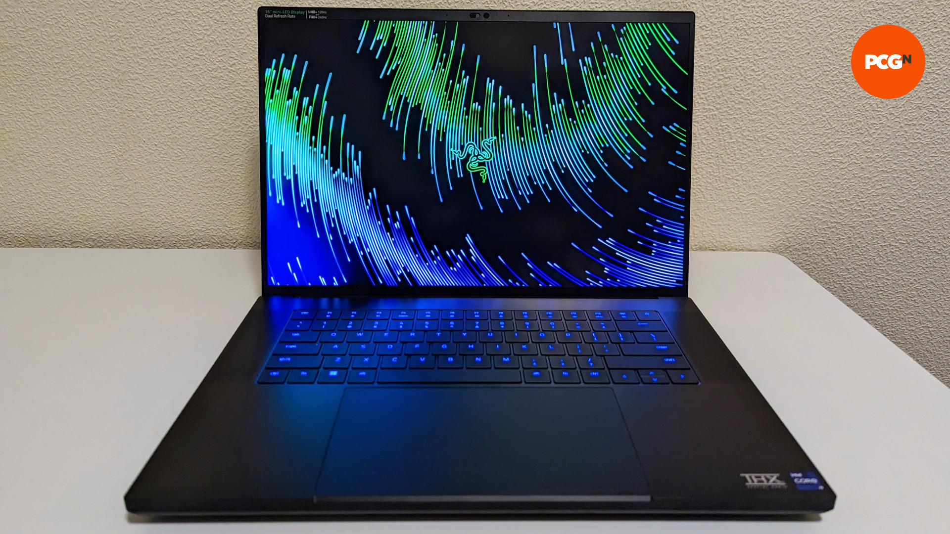 Razer Blade 16 (2023) review: A front view of hte laptop, its Razer desktop wallpaper shining brightly in green and blue