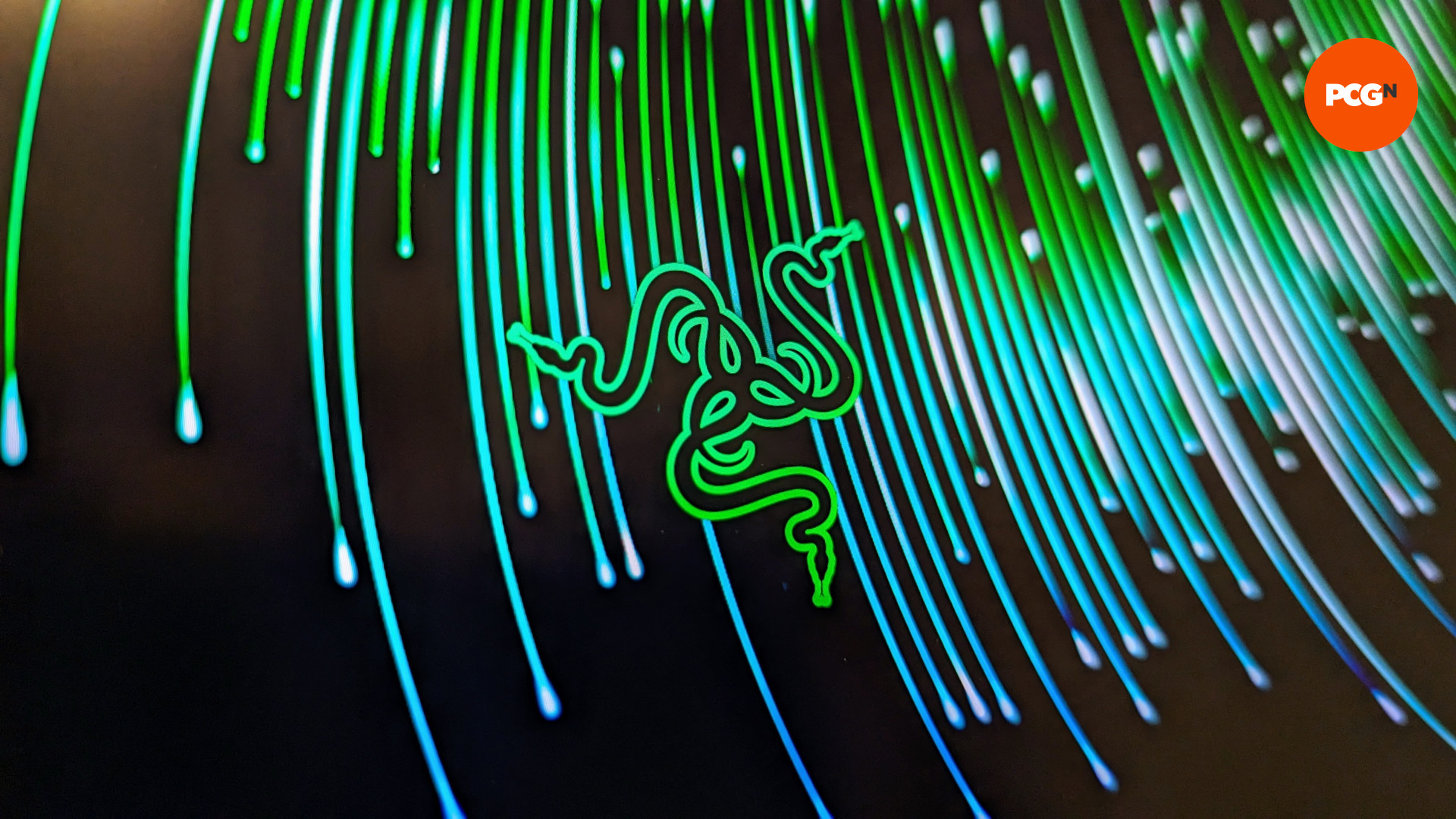 Razer Blade 16 (2023) review: A close up of the Razer logo against swirls of green and blue