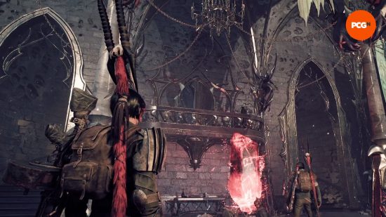 Remnant 2 review: Two travelers stands in a stone hall adorned in gleaming decorative accoutrements, lofty chandeliers, and chain bunting.