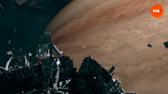 A woman in a spacesuit flies in front of a huge brown planet with debris underneath