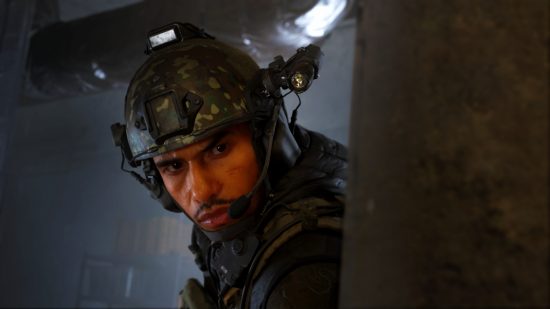 Modern Warfare 3 reveal: A man wearing military armor peaks out from behind a wall, his facial expression serious