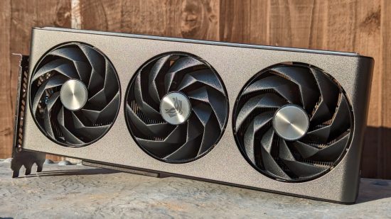 AMD Radeon RX 7800 XT review: The Sapphire Nitro model of the graphics card rests atop a metal surface with a wood backdrop