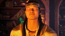 Liu Kang is one of the most important Mortal Kombat 1 characters. Here he is standing near a fireplace as the flames illuminate his face.