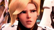 Overwatch 2 Season 6 balance changes - Mercy, a blonde woman in a white set of armor, narrows her eyes in concern.