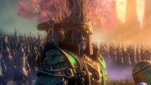 Total War Warhammer 3 Shadows of Change: a man in gold and green armor stands in front of a pink cherry blossom tree
