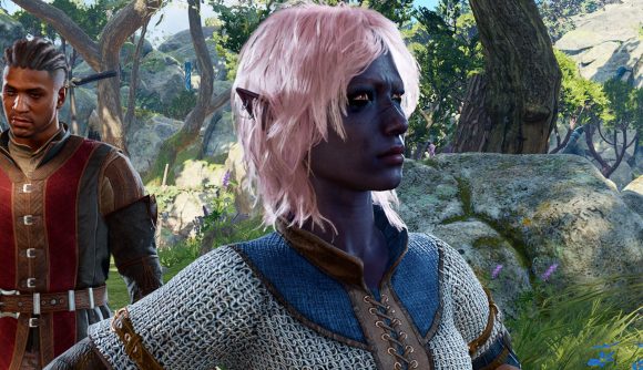 An elf character with rose gold hair and dark purple skin wearing chainmail armor stands in a forest frowning