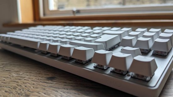 Logitech G Pro X TKL Lightspeed review: a white keyboard appears side on above a wooden worktop.