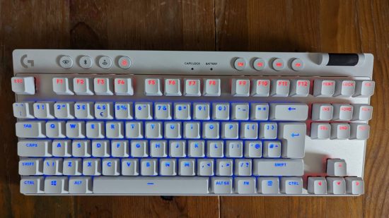 Logitech G Pro X TKL Lightspeed review: a white keyboard appears on a wooden worktop showing blue and orange RGB.