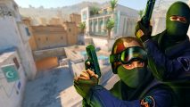 Counter-Strike 2 AMD VAC ban: Two men wearing green ski masks and military gear hold their guns up, a desert cityscape behind them