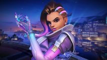 Overwatch 2 Sombra rework: A woman with purple highlights in her hair and purple armor wields a gun, smiling, with a city backdrop behind her