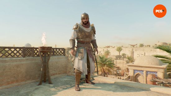 Basim is wearing the Abbasid Knight AC Mirage outfits, while standing on a rooftop next to a torch.
