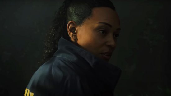 Is Alan Wake 2 on Game Pass: FBI agent Saga Anderson glances over her shoulder, ensconsed in the woods surrounding Bright Falls.