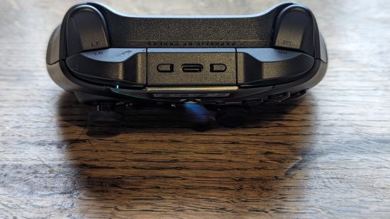 Asus ROG Raikiri Pro review: a black controller appears on a wooden desk with the top of the controller pointing to camera.
