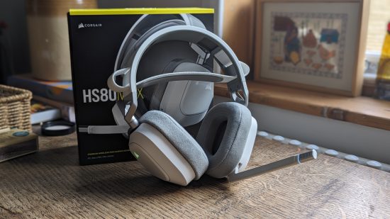 Corsair HS80 Max review: a white headset appears with a black box on a wooden table.