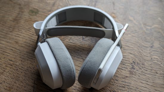 Corsair HS80 Max review: a white headset with retracted microphone appears on a wooden table.