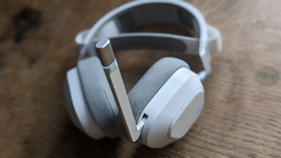Corsair HS80 Max review: a white headset with extended microphone appears on a wooden table.