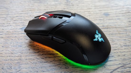 Razer Cobra Pro review: a black mouse with multicolored RGB appears on a wooden surface.