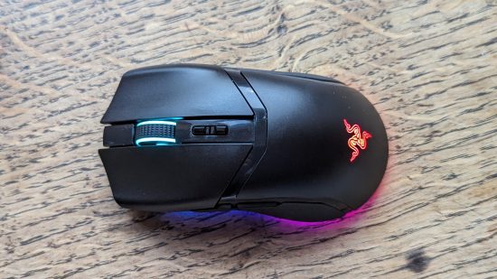 Razer Cobra Pro review: a black mouse with multicolored RGB appears on a wooden surface.