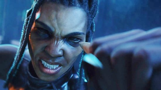 A black woman with dark black eyes and huge fangs punches at the camera holding a knife