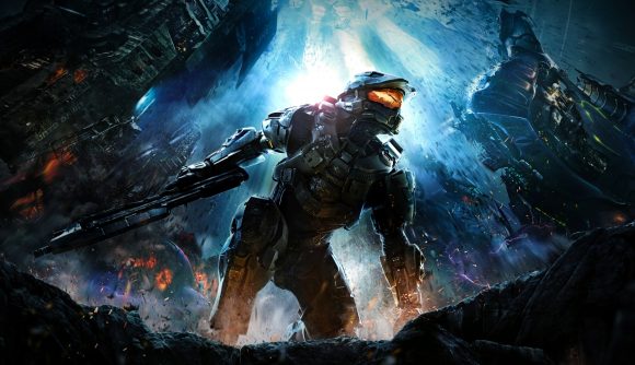 Halo sale: Master Chief, a large figure in mech-like military armor, rises from the ground with his gun in hand