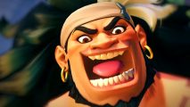 Overwatch 2 new hero Mauga: A broadly built man with thick dark eyebrows and long black hair smiles wide, his teeth showing and gold earrings dangling