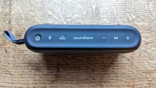 Anker Soundcore Motion 300 review: a black speaker with silver grille appears on a wooden surface.