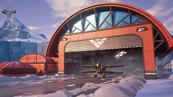A shot of an aircraft hanger in Fortnite, with biplanes flying in the distance