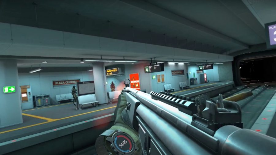 First-person view of a submachine gun aimed at enemies standing on the other side of a tube track.