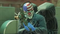 Payday 3 update free: a man reloading an AR on a rooftop, with a duffle bag slung over his shoulder a black leather jacket on, wearing a clown mask with the American flag on it