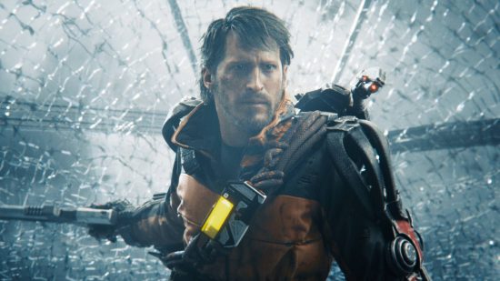 A grizzled man in a an orange combat suit stands against a background of shattered class with his pistol ready