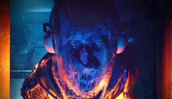 Displacement horror game: A man wearing a white headset and netting around his head stares ahead, his eyes showing through the veil as an orange light glows beneath his face