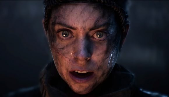 Hellblade sale: A woman with dirt covering her pale face stares ahead surprised, her mouth open and blue eyes wide