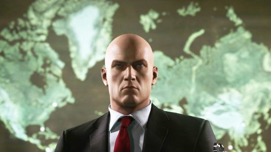 A bald, business-suit wearing man looking sternly at the viewer.