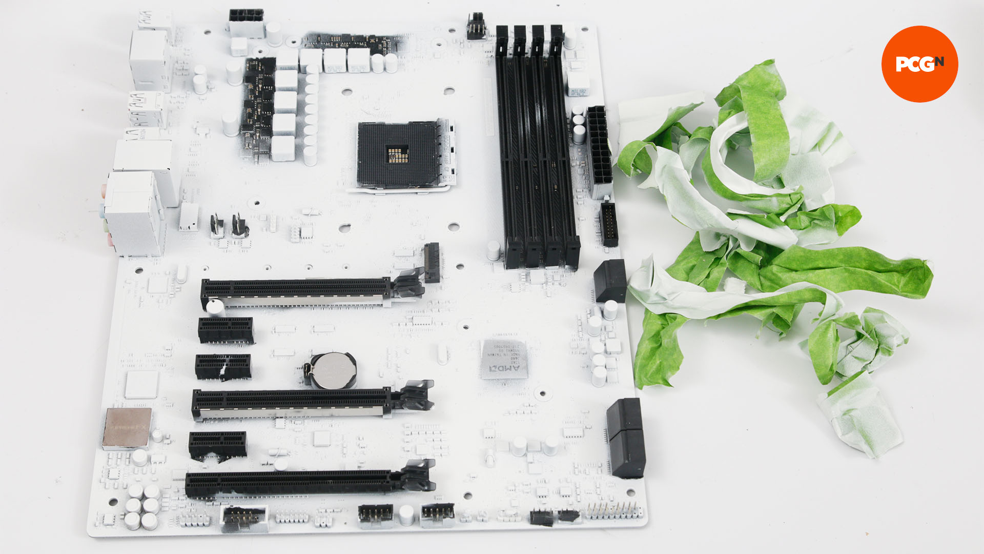 The masking tape is removed from the freshly painted white motherboard