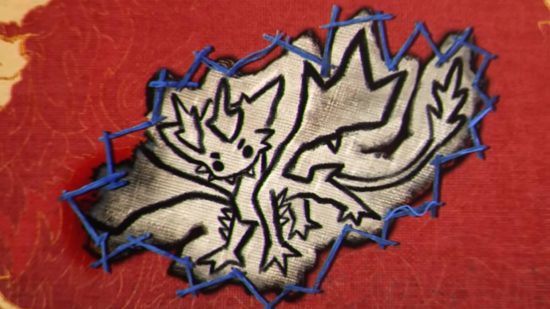 A cute drawing of a small dragon creature stitched onto red fabric