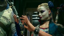 Harley Quinn, a woman with pancake make-up on her face, looking at her hands.