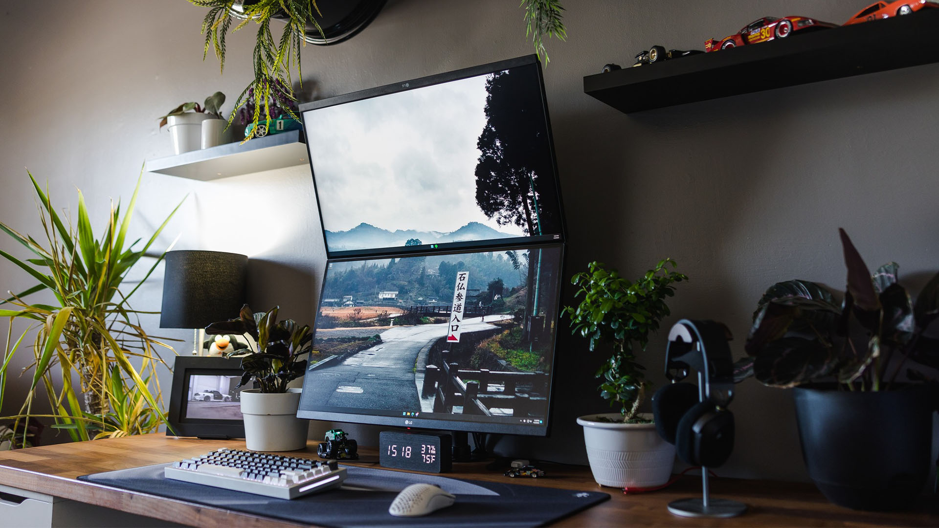 Dos monitores, uno en ángulo, frente a un escritorio en un automóvil y una sala de juegos con temática vegetal