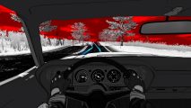 A black and white car interior driving along a road into a red sunset