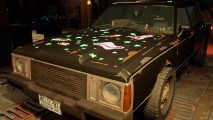 Pacific Drive review: The Remnant car, customized with glow in the dark space decals and a matte black finish.