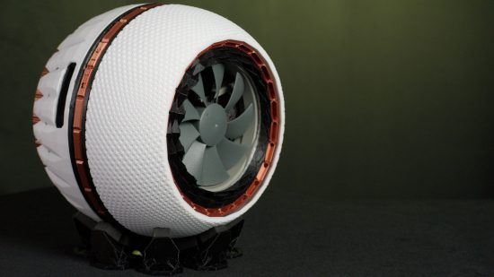 A spherical 3D printed case in white and brown with a grey fan at the front
