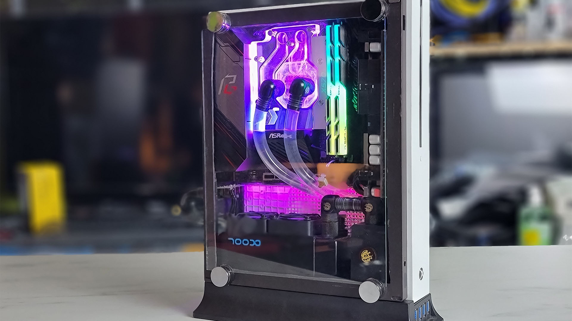 The inside of a Xbox One S PC with neon lights and water cooling