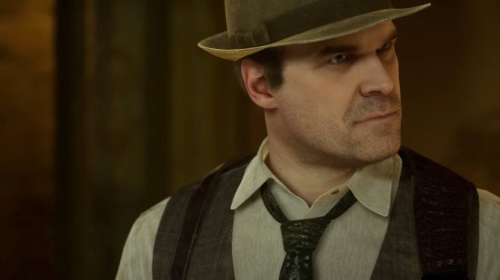 Edward Carnby, played by David Harbour in the Alone in the Dark cast, looks off to his right, and he wears a hat, a loose-fitting tie, and a waistcoat.
