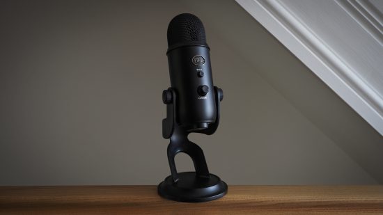 Blue Yeti review image showing a microphone standing on a table bear a window.