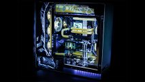 A yellow and blue water cooled gaming PC which has a broken crystal glass design