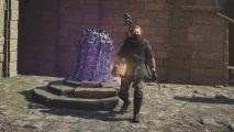 Dragon's Dogma 2 Portcrystals: a man stands next to a glowing purple stone.